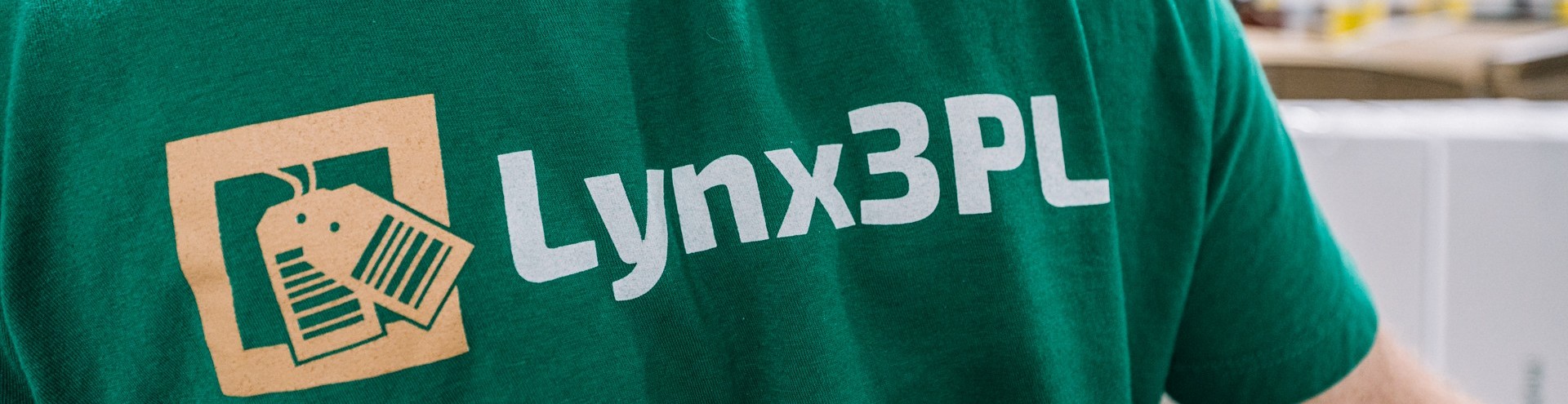 A close-up of Lynx3PL logo on a green staff shirt.